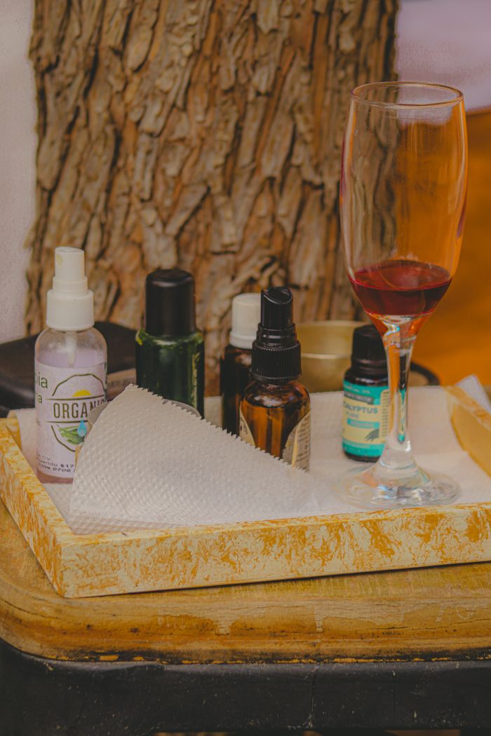 A luxurious spa scene featuring essential oils and a glass of red wine, perfect for relaxation.