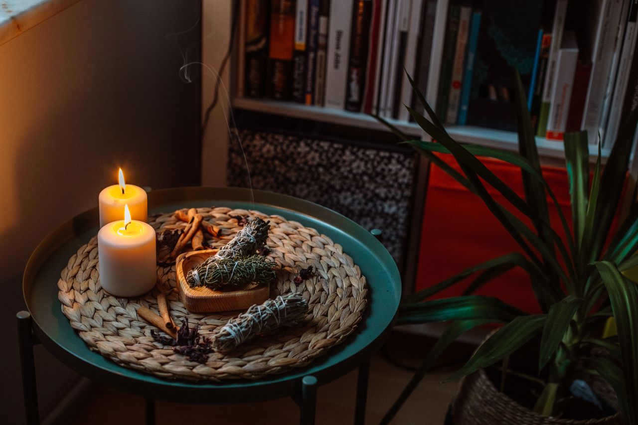 A serene home interior scene featuring lit candles and incense sticks, creating a calm atmosphere.